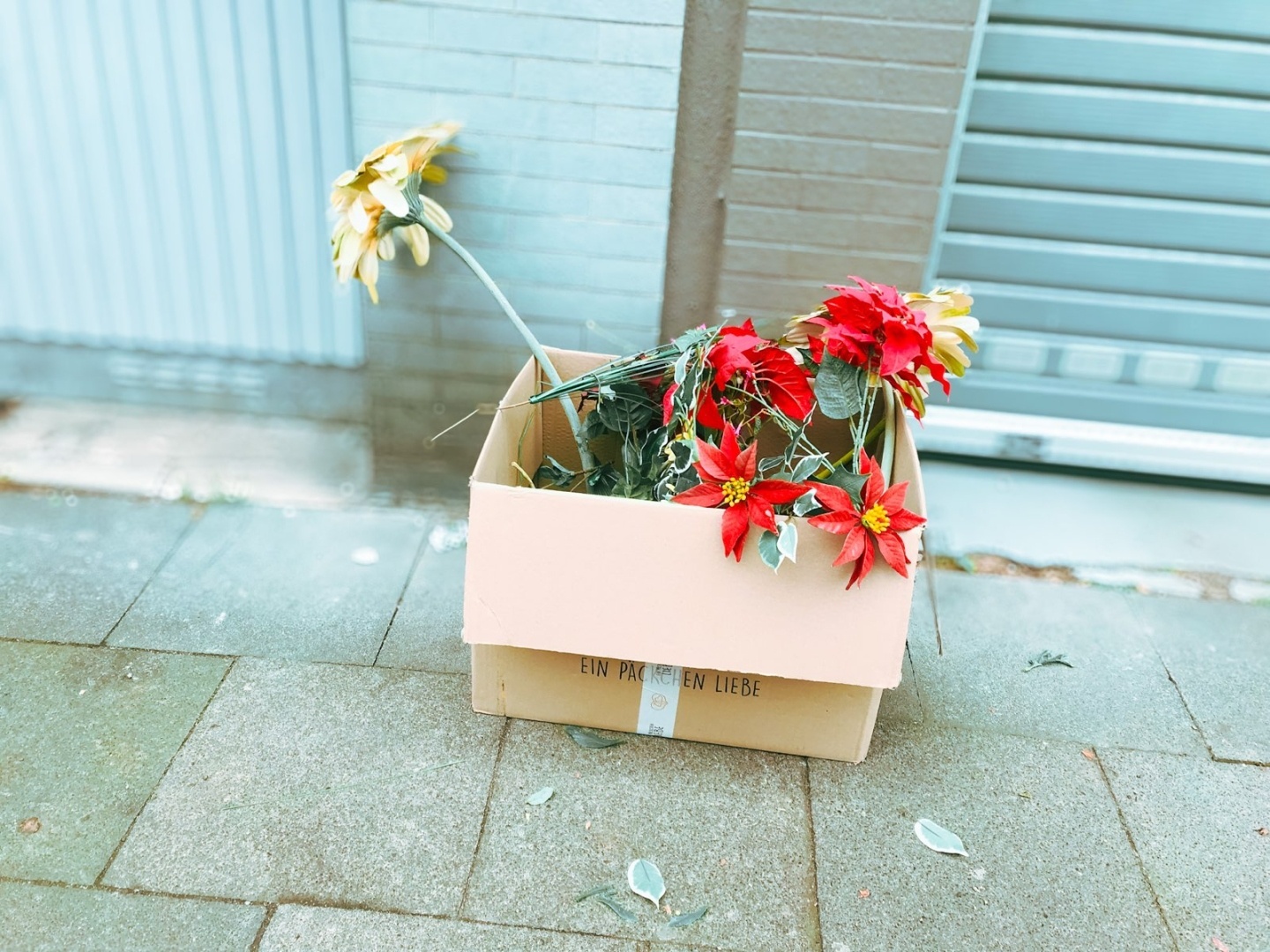 Umzugskarton mit Plastikblumen