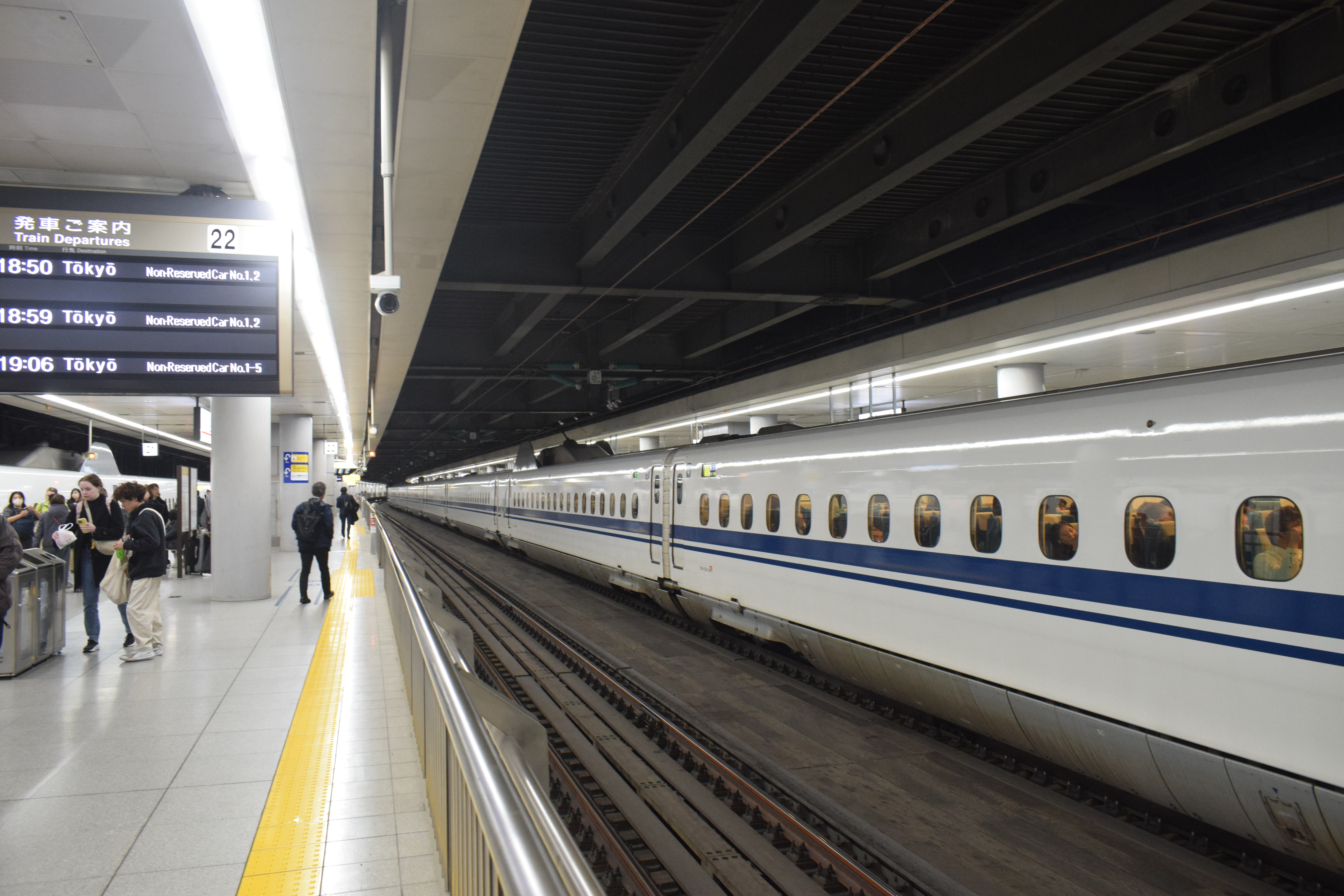 A shinkansen train can be seen on the right and a train platform on the left. This photo was taken at the JR Shinagawa station in Tokyo.