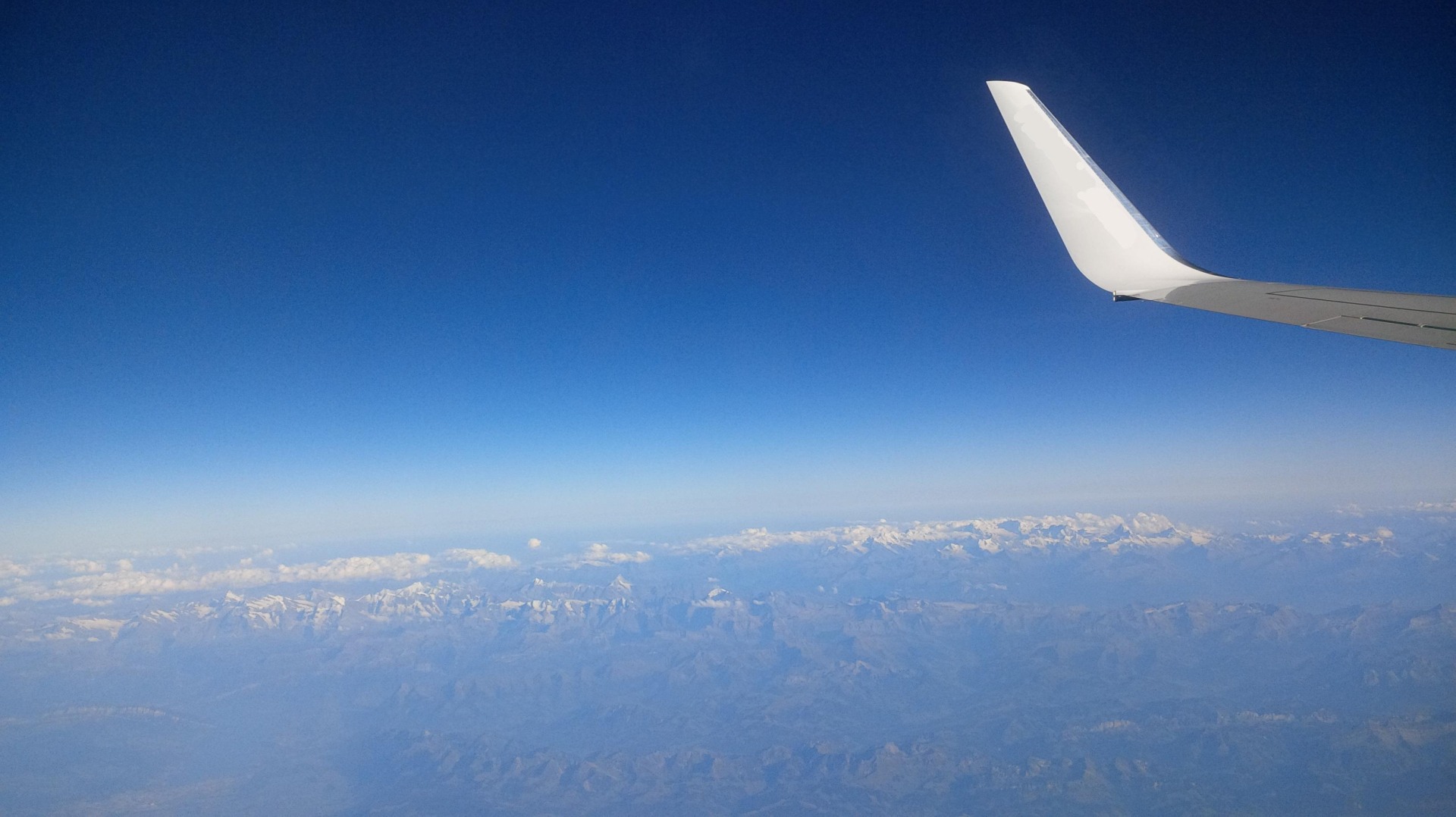 Blick auf die Alpen aus dem Flugzeugfenster
