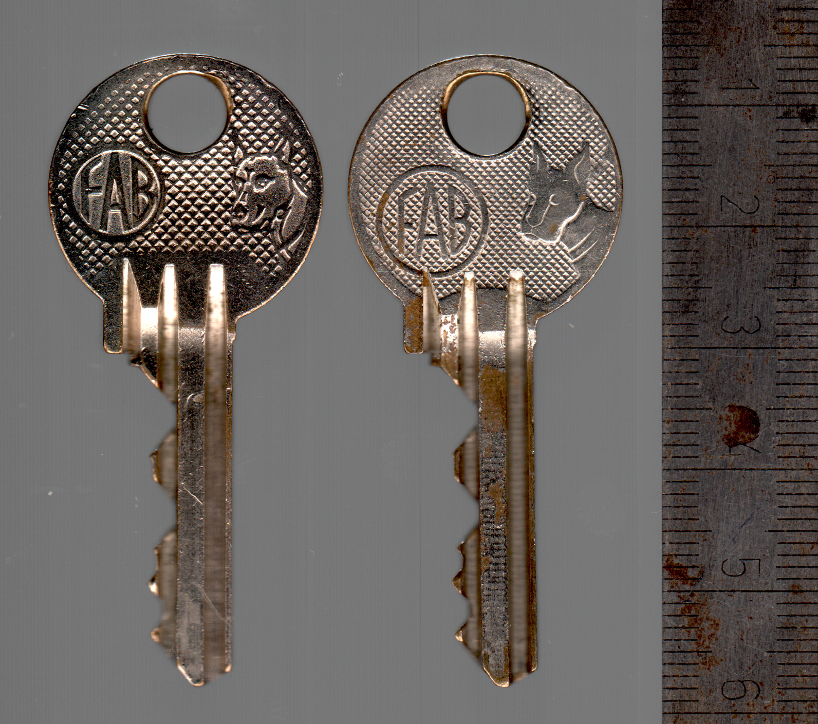 FAB 2018 keys, original on the right, a modern copy on the left, both featuring the FAB marking and the iconic Dog.